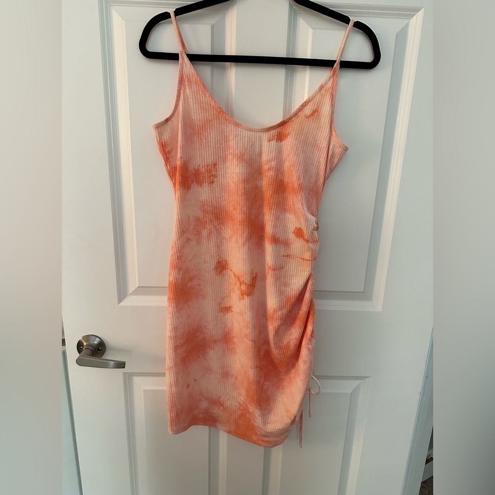 Coral colored tie dye body con dress. Ruched side which is adjustable. Size L